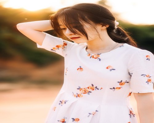 Woman meditating in nature during sunset with soft lighting