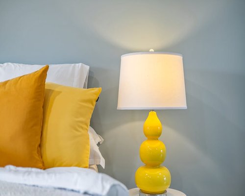 Cozy bedroom interior with soft yellow lighting and comfortable pillows